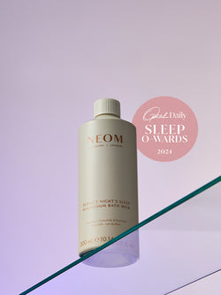NEOM bottle on a reflective surface with a pink 'Oprah Daily Sleep O'Wards 2024' label.