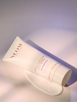 NEOM skincare product on a soft gray background