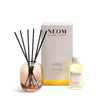Neom Happiness Reed Diffuser set with bottle and packaging on a white background