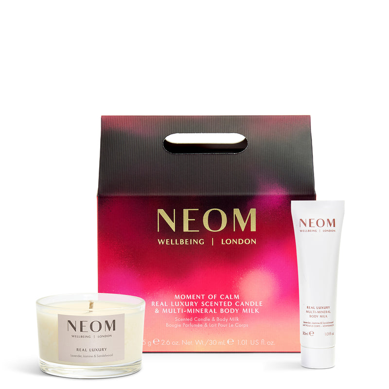 NEOM candle, body milk, and packaging on a white background