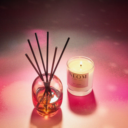 Neom candle and diffuser set on a pink and purple gradient background