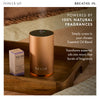 Neom diffuser on a wooden surface with essential oil packaging, text about natural fragrances.