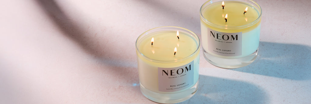 Two NEOM candles on a light background
