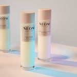 Three NEOM bath foam bottles on a gradient background