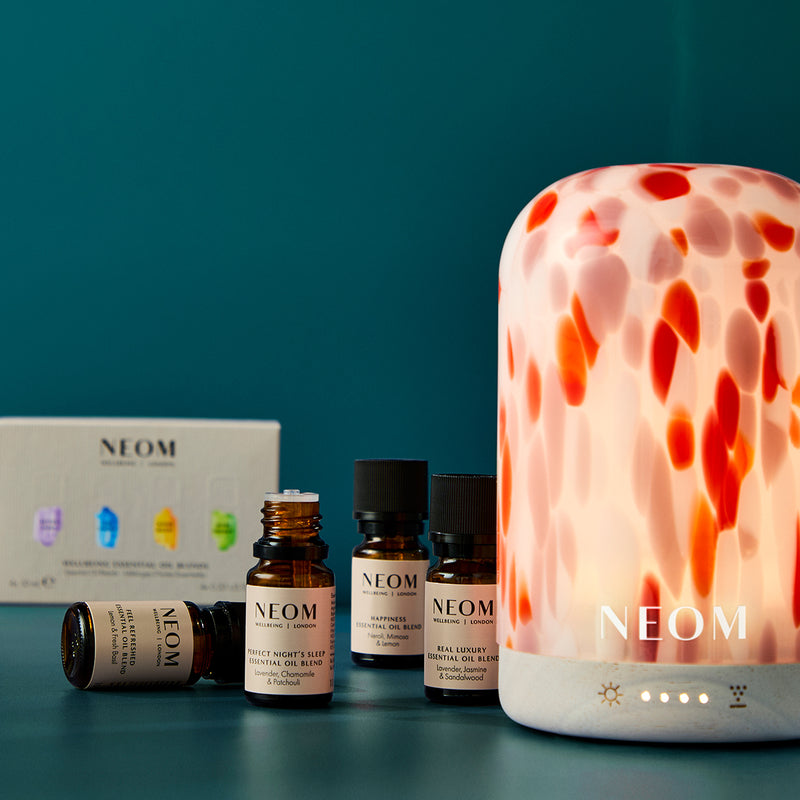 NEOM products including a diffuser and packaging on a teal background