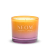 Neom candle with gradient orange to pink design on a white background