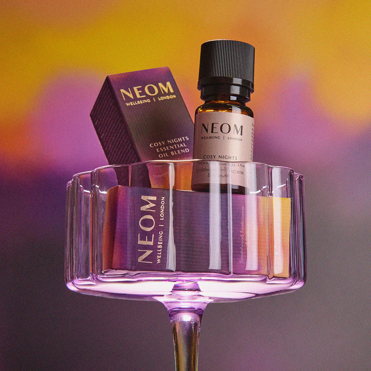 Neom products including a bottle and packaging on a gradient background