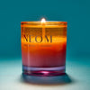 NEOM candle with a gradient color on a blue background