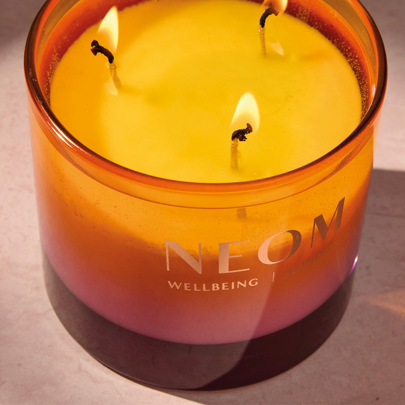 NEOM Cosy Night's wellbeing candle with three wicks on a neutral background