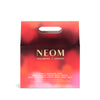 NEOM packaging with red and pink gradient on a white background