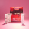 NEOM skincare products on a pink background