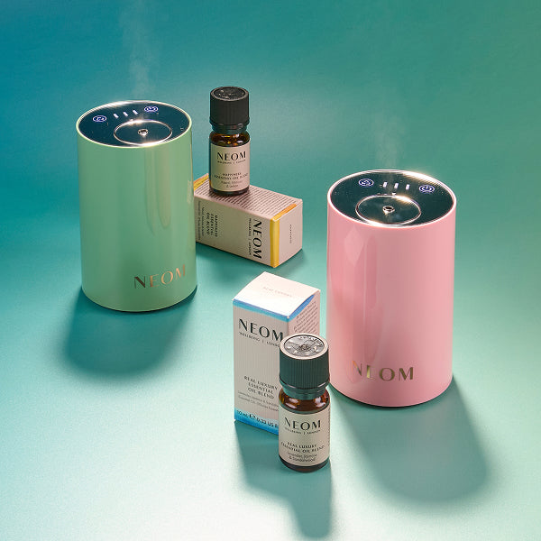 NEOM products including diffusers and essential oils on a gradient blue background
