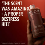 “Hand holding NEOM Feeling Grounded Body Wash against a red background. Large text reads: ‘The scent was amazing – a proper destress hit!’ Small print: ‘*Independent blind study on 77 people, after initial use.’”