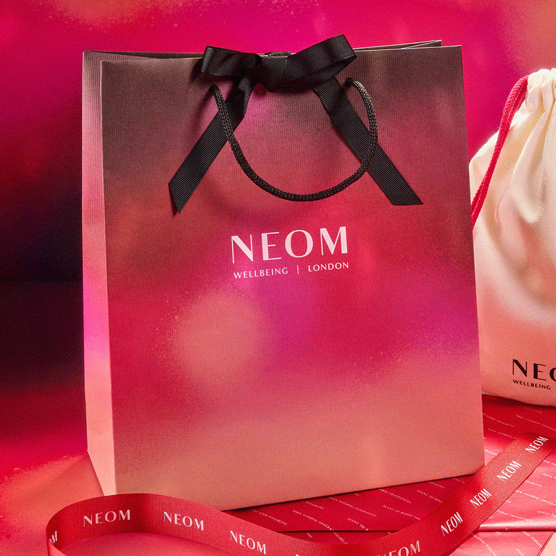 Neom shopping bag with a black ribbon on a red background