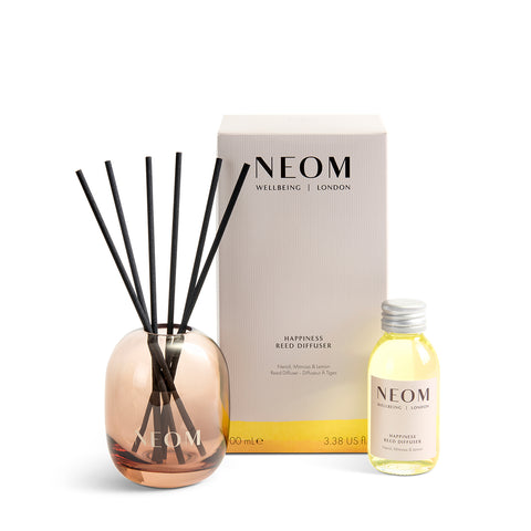Neom Happiness Reed Diffuser set with bottle and packaging on a white background
