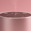 Close-up of a pink diffuser device with control panel on a pink background