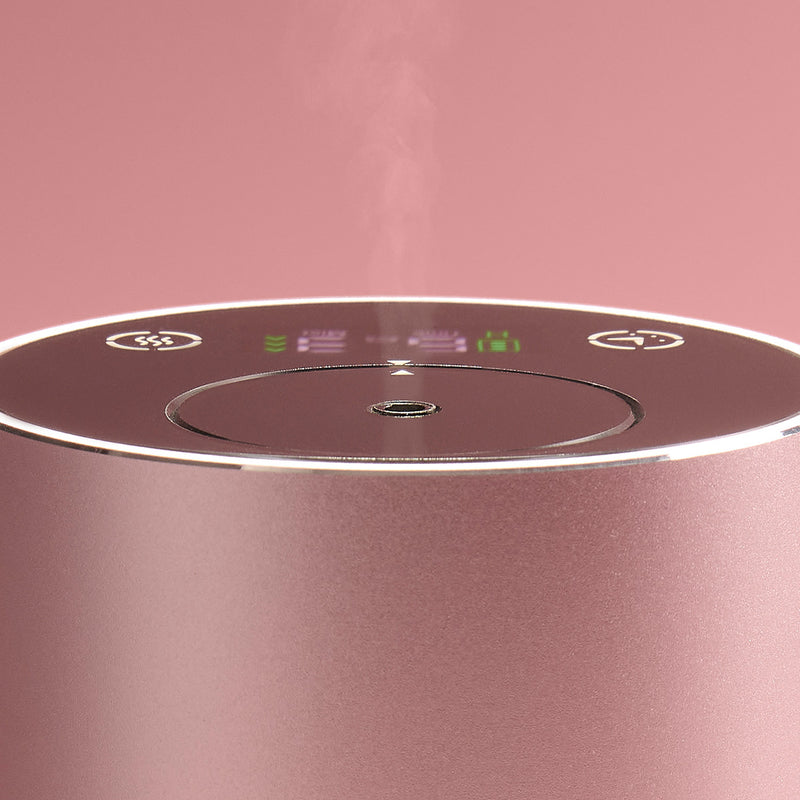 Close-up of a pink diffuser device with control panel on a pink background