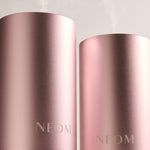 Two rose gold NEOM diffusers on a light gray background