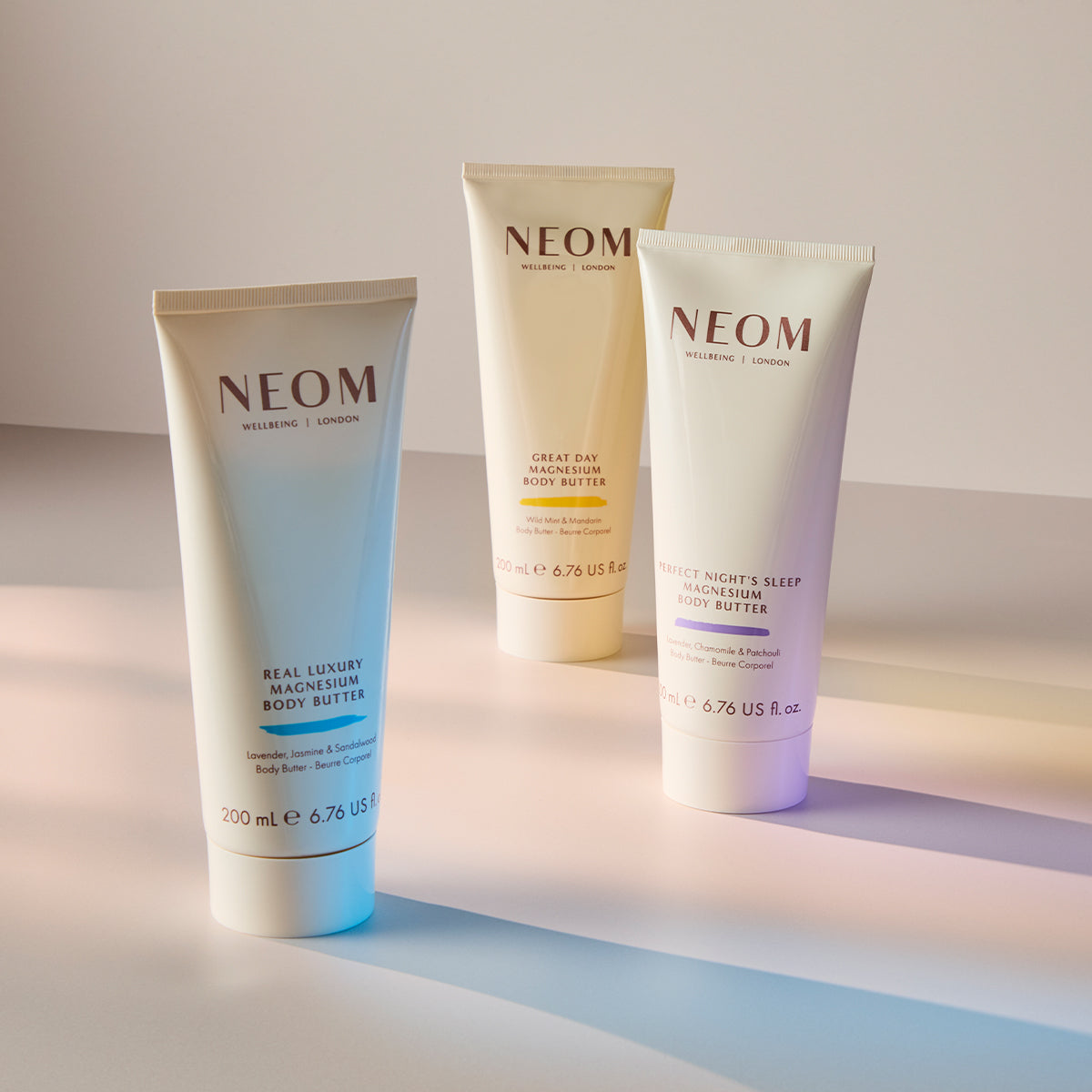Three NEOM skincare products on a gradient background