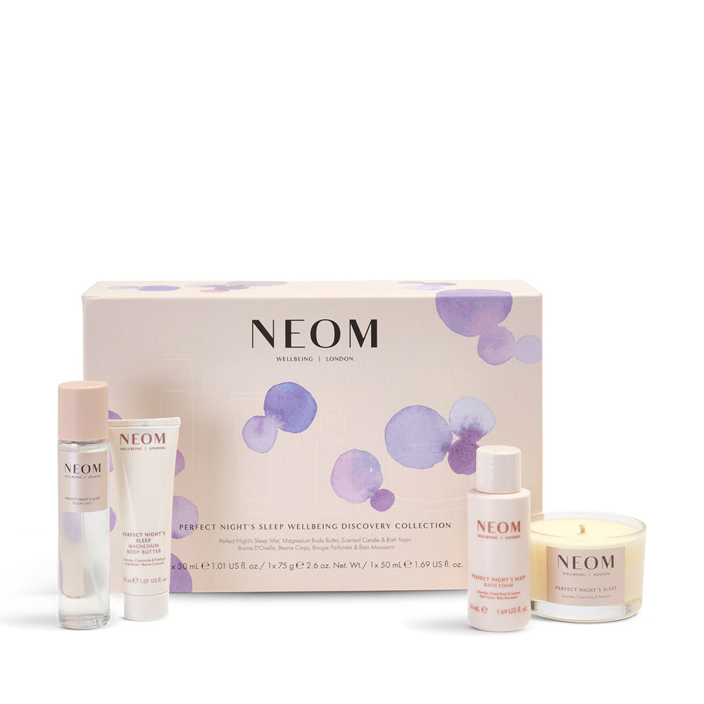 NEOM Perfect Night's Sleep Wellbeing Discovery Collection product set including a sleep mist, body butter, bath foam, and travel candle, packaged in a box with purple dots design.