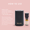 NEOM essential oil diffuser and bottle on a pink background with text on how to use.
