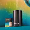 NEOM products including a black cylindrical container, a small bottle, and packaging on a gradient background.
