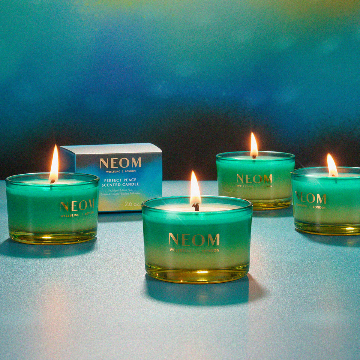 Neom candles with a blue gradient on a reflective surface and blue background