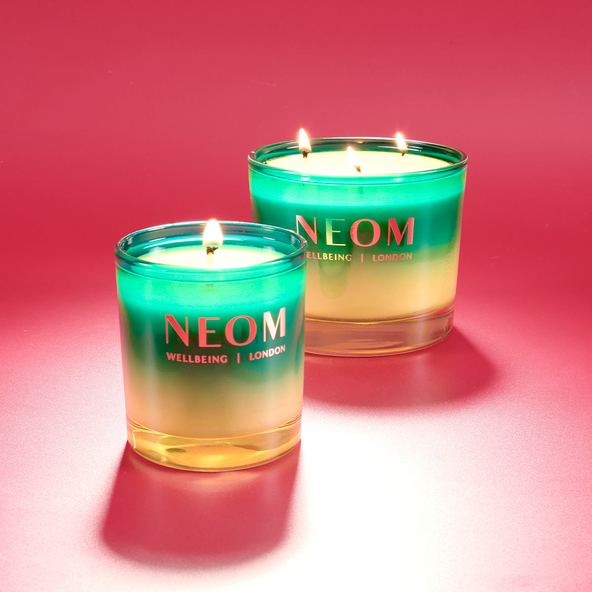 Two NEOM candles on a red background