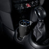 Car interior with a cup holder and gear shift, featuring a NEOM pod mini diffuser product.