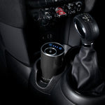 Car interior with a cup holder and gear shift, featuring a NEOM pod mini diffuser product.