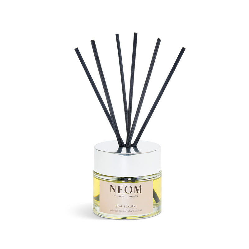 NEOM diffuser with black sticks on a white background