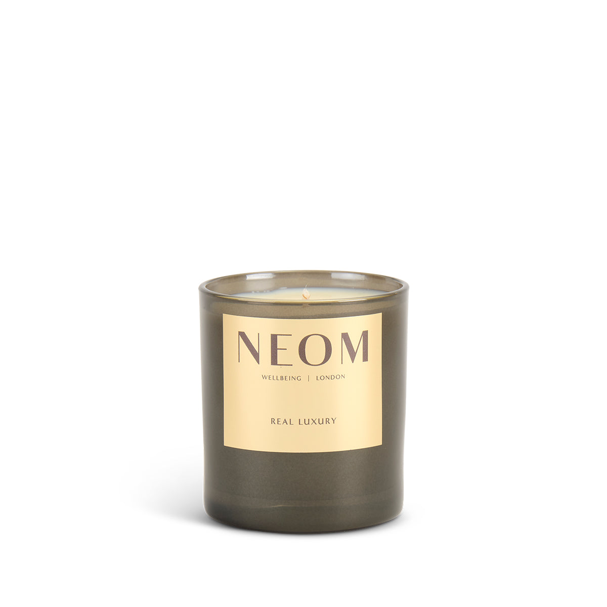 NEOM candle with a gold label on a white background