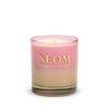 Neom candle with a pink and beige gradient on a white background