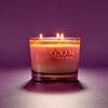 NEOM candle with a purple gradient on a matching purple background