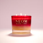 NEOM candle with a gradient design on a light background